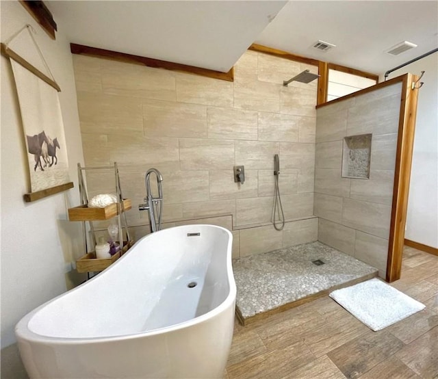 bathroom with hardwood / wood-style flooring and separate shower and tub