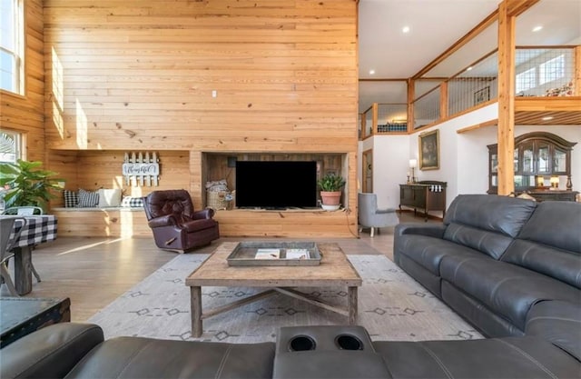 living room with wood walls, wood-type flooring, and a high ceiling