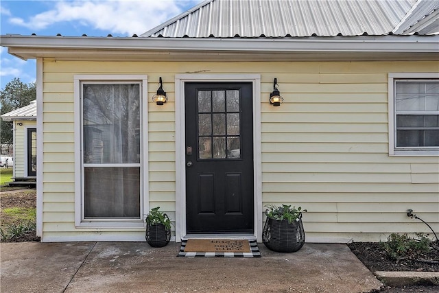 view of exterior entry with a patio