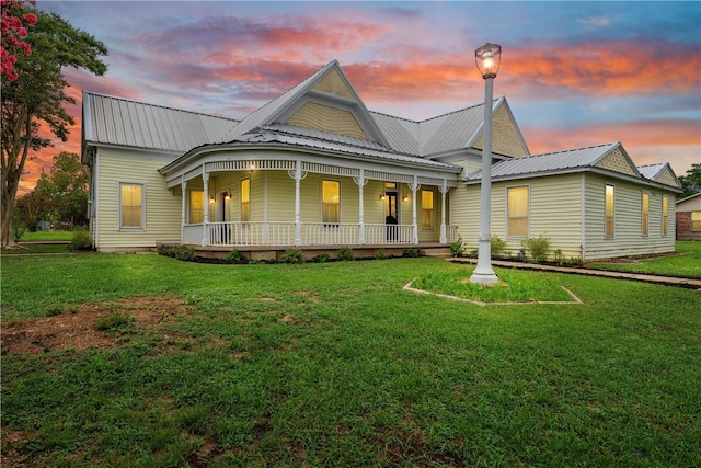 view of front of house with a porch and a yard