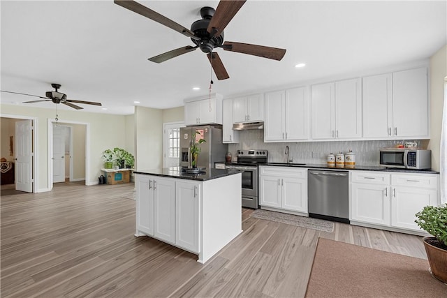 kitchen with white cabinets, appliances with stainless steel finishes, light hardwood / wood-style floors, and sink