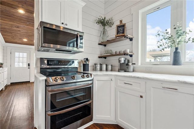 kitchen featuring white cabinets, appliances with stainless steel finishes, dark hardwood / wood-style flooring, and a wealth of natural light