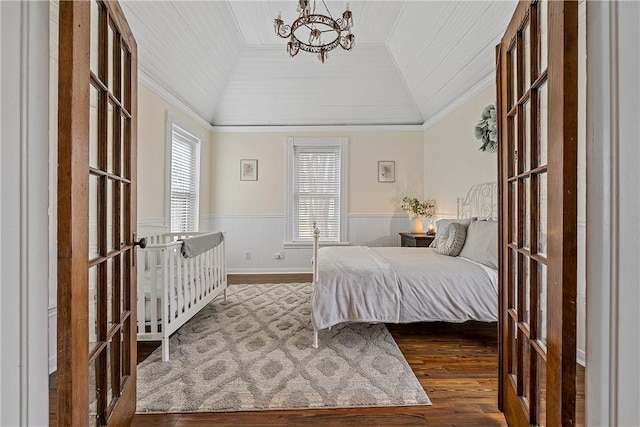 bedroom featuring dark hardwood / wood-style flooring, french doors, vaulted ceiling, and ornamental molding