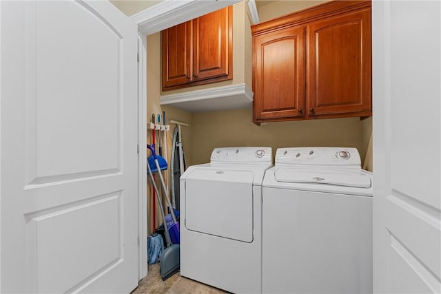 washroom with cabinets and washing machine and clothes dryer