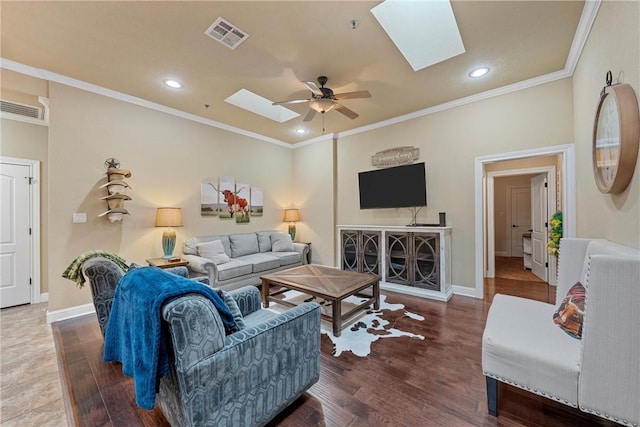 living room featuring a skylight, ceiling fan, crown molding, and dark wood-type flooring