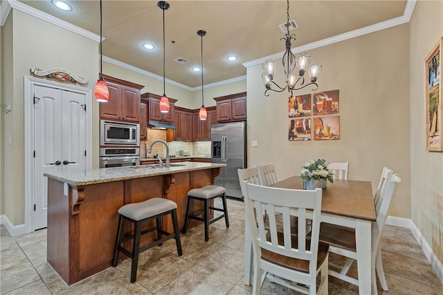 kitchen featuring backsplash, an inviting chandelier, hanging light fixtures, an island with sink, and stainless steel appliances