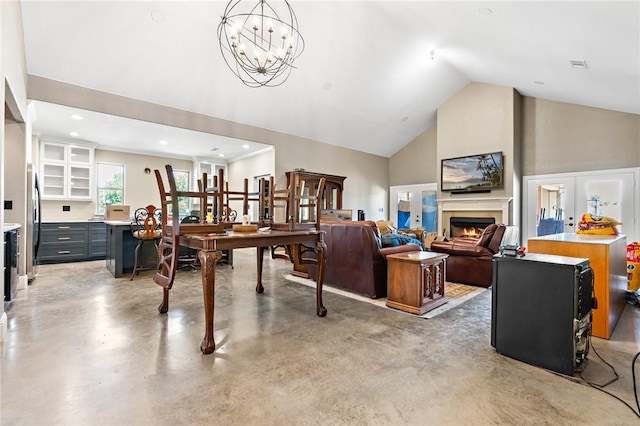 living room with a chandelier, french doors, concrete floors, and lofted ceiling