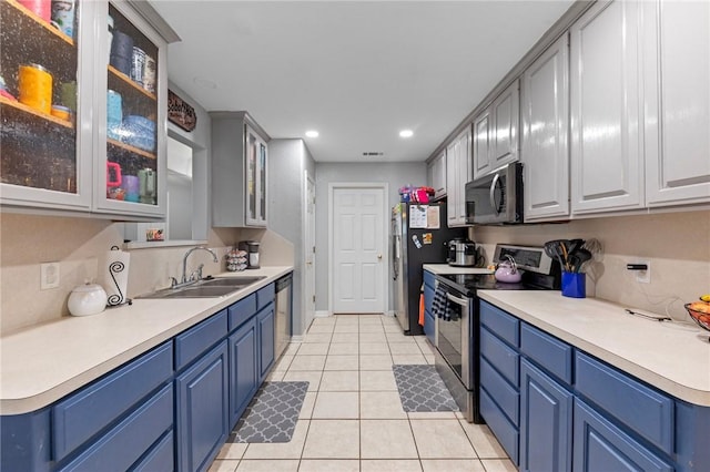 kitchen featuring sink, light tile patterned floors, blue cabinetry, and appliances with stainless steel finishes