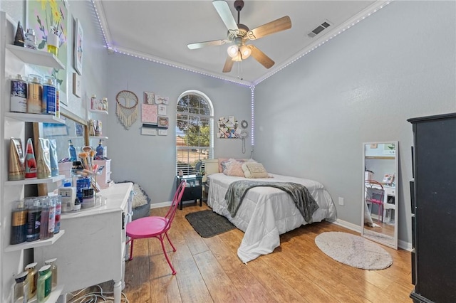 bedroom featuring hardwood / wood-style flooring, ceiling fan, and ornamental molding