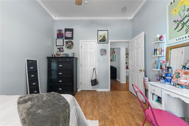 bedroom featuring light wood-type flooring, ceiling fan, and crown molding