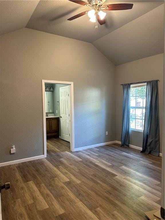 spare room with dark hardwood / wood-style flooring, vaulted ceiling, and ceiling fan