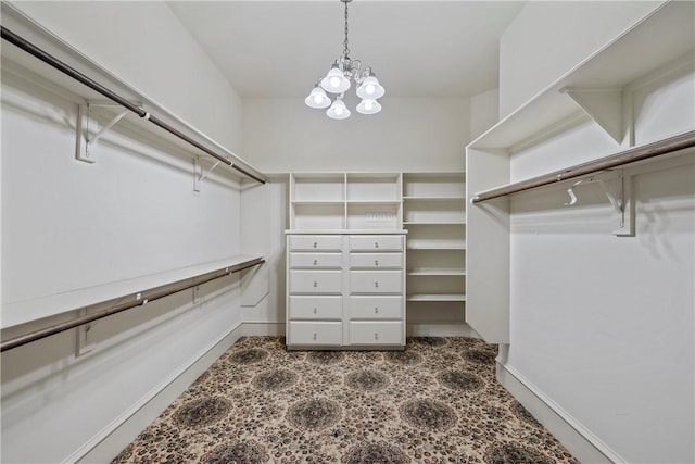 spacious closet with an inviting chandelier