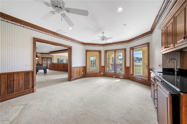 kitchen featuring pool table, light colored carpet, crown molding, ceiling fan, and sink