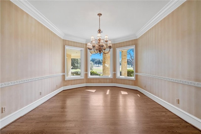 spare room featuring hardwood / wood-style flooring, crown molding, and a chandelier