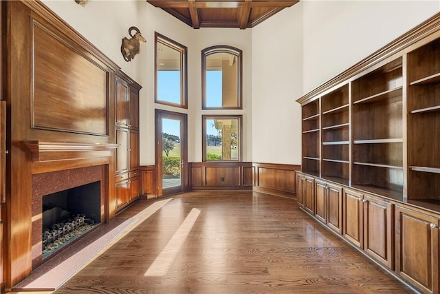 interior space featuring beam ceiling, coffered ceiling, built in features, and dark hardwood / wood-style floors