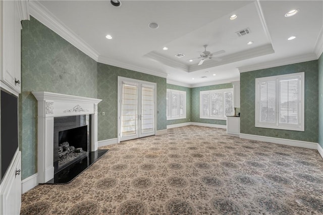 unfurnished living room featuring ornamental molding, ceiling fan, french doors, and a tray ceiling