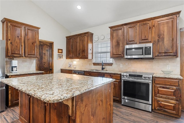 kitchen featuring a sink, vaulted ceiling, dark wood-type flooring, and stainless steel appliances