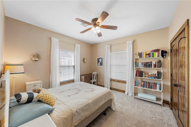 bedroom with light carpet, visible vents, a ceiling fan, and baseboards