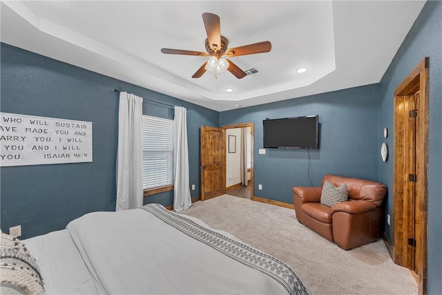 carpeted bedroom with visible vents, baseboards, a tray ceiling, recessed lighting, and ceiling fan