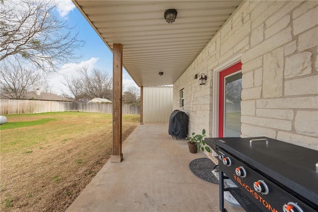 view of patio with a grill and fence