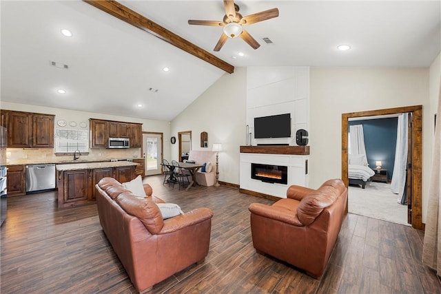 living area with beam ceiling, visible vents, a large fireplace, and dark wood-style flooring