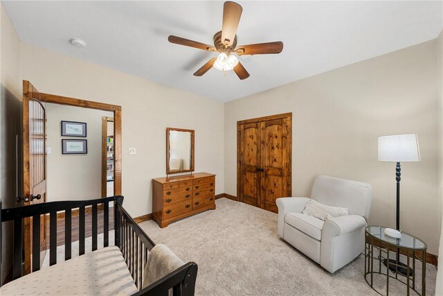 bedroom featuring light carpet, a ceiling fan, and baseboards