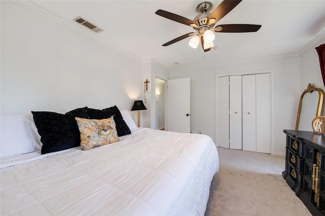 bedroom featuring ceiling fan, a closet, light colored carpet, and ornamental molding