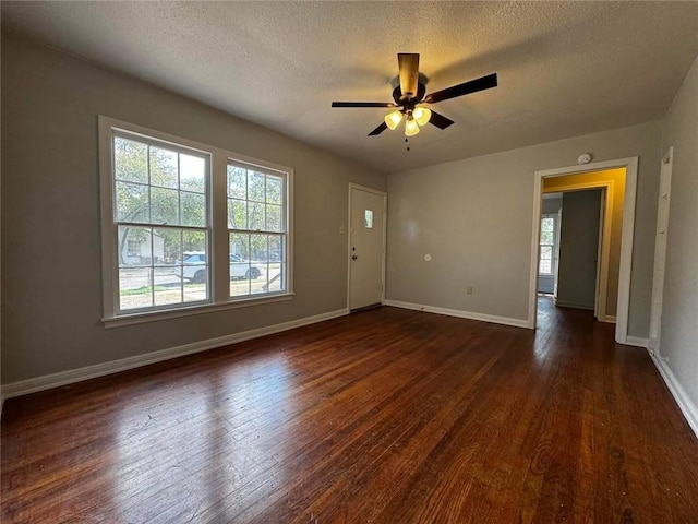 empty room featuring a textured ceiling, ceiling fan, and dark hardwood / wood-style floors