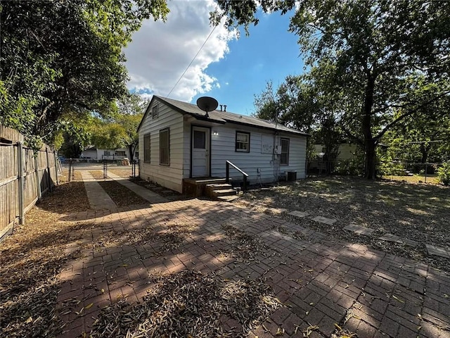 rear view of property with central AC and a patio