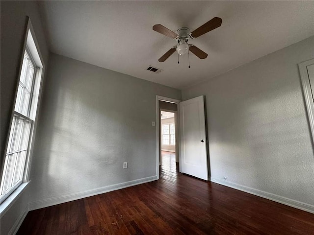 empty room with dark hardwood / wood-style floors and ceiling fan