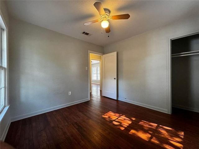 unfurnished bedroom featuring a closet, ceiling fan, and dark hardwood / wood-style floors