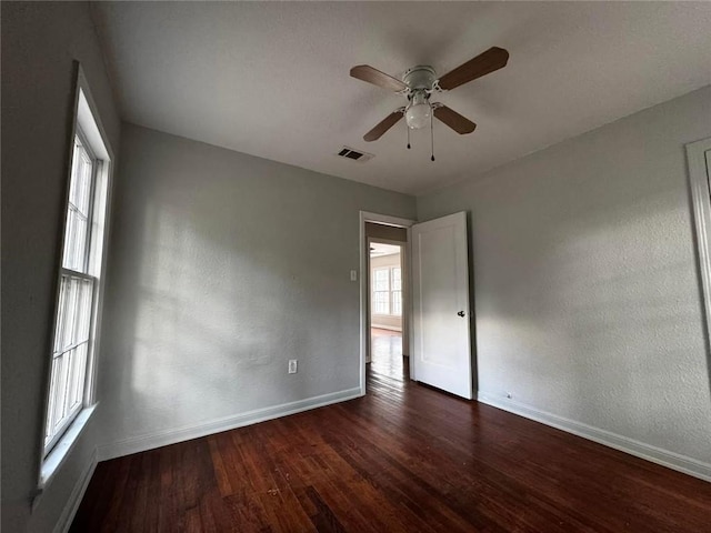 empty room with ceiling fan and dark hardwood / wood-style floors