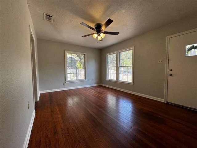 unfurnished room featuring a textured ceiling, ceiling fan, and dark wood-type flooring