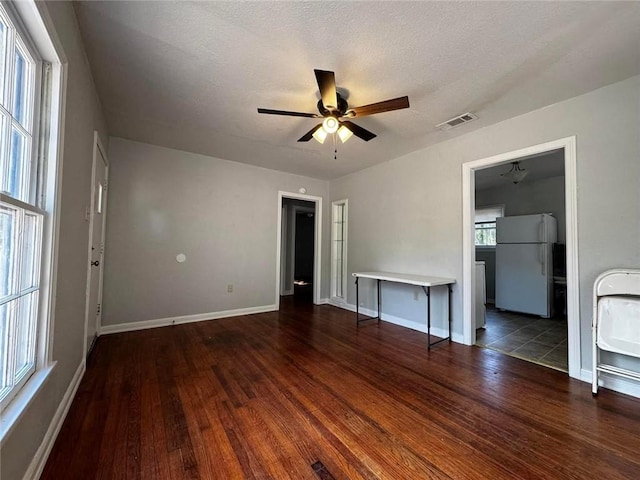 spare room with ceiling fan, dark hardwood / wood-style flooring, and a textured ceiling