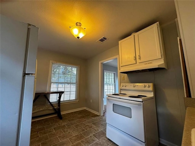 kitchen with a textured ceiling, white cabinets, and white appliances