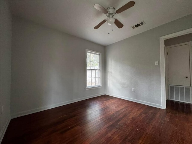 empty room with ceiling fan and dark wood-type flooring