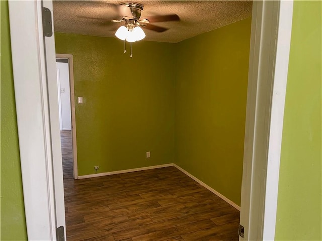 empty room with a textured ceiling, ceiling fan, and dark wood-type flooring