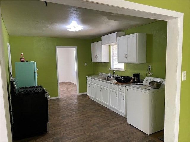 kitchen with black range with gas stovetop, sink, white refrigerator, washer / dryer, and white cabinetry