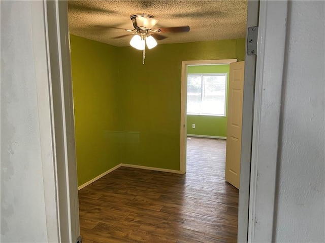 empty room featuring a textured ceiling, dark hardwood / wood-style flooring, and ceiling fan