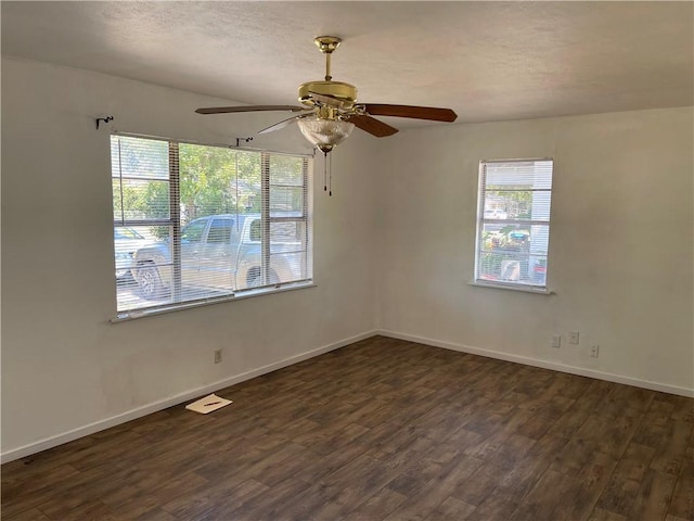 empty room with ceiling fan and dark wood-type flooring