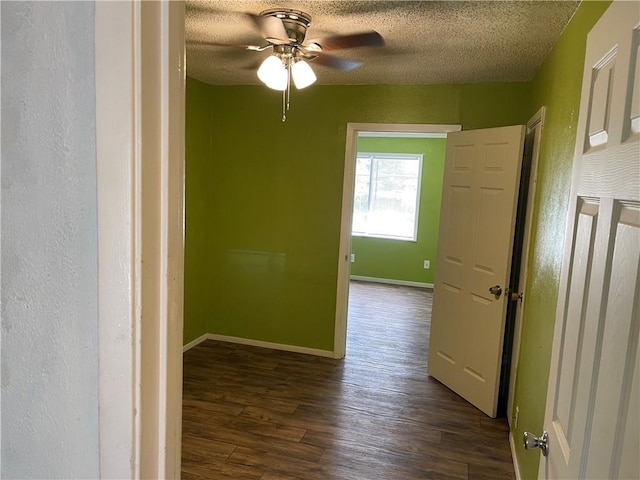 interior space with ceiling fan, dark hardwood / wood-style flooring, and a textured ceiling