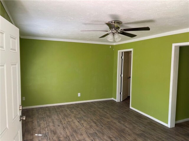 spare room with a textured ceiling, dark hardwood / wood-style floors, ceiling fan, and crown molding