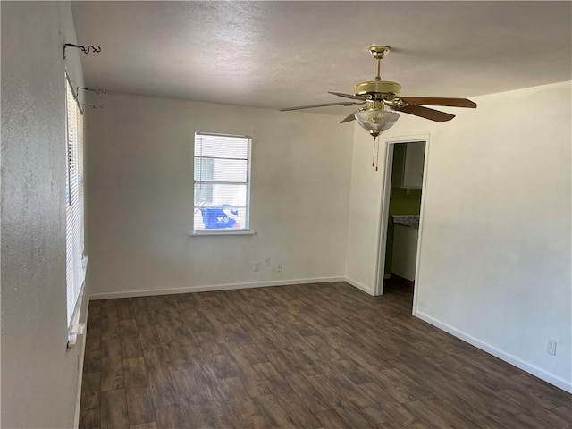 unfurnished room featuring ceiling fan and dark wood-type flooring