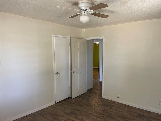 spare room with ceiling fan, dark wood-type flooring, and a textured ceiling