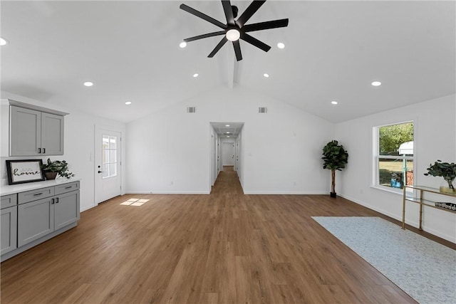 living room with vaulted ceiling with beams, light hardwood / wood-style floors, and ceiling fan