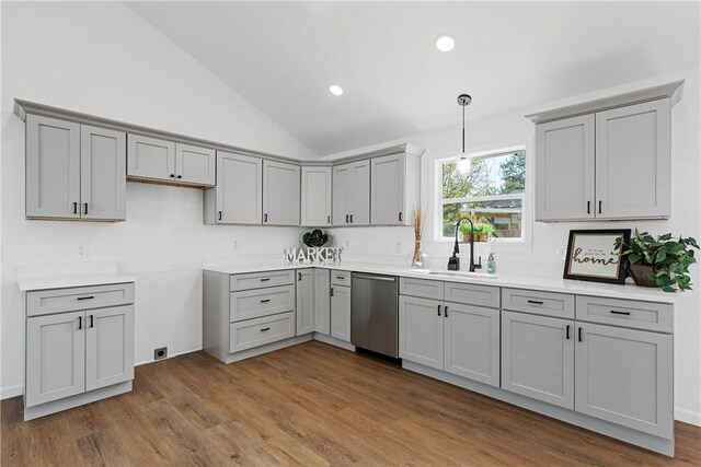 kitchen featuring sink, stainless steel dishwasher, wood-type flooring, lofted ceiling, and decorative light fixtures