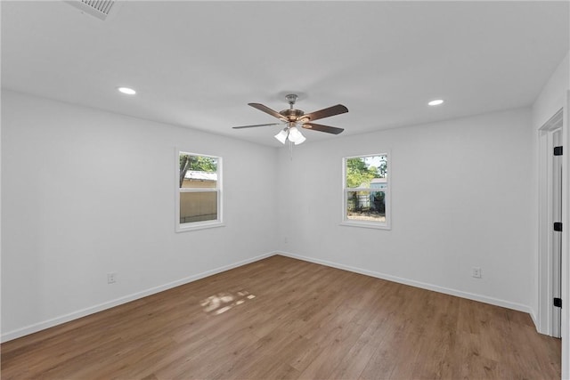 unfurnished room with ceiling fan, light wood-type flooring, and a wealth of natural light