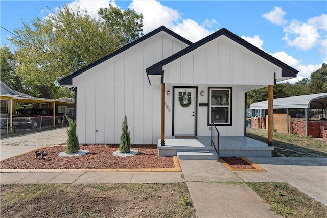 modern inspired farmhouse with a porch and a carport