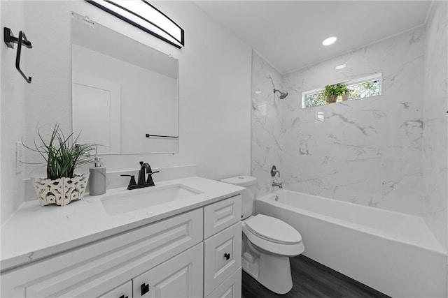 full bathroom with vanity, toilet, tiled shower / bath, and hardwood / wood-style flooring