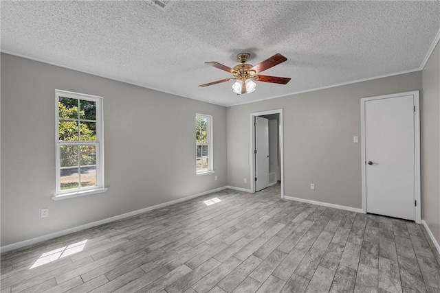 unfurnished room featuring a healthy amount of sunlight, baseboards, and wood finished floors